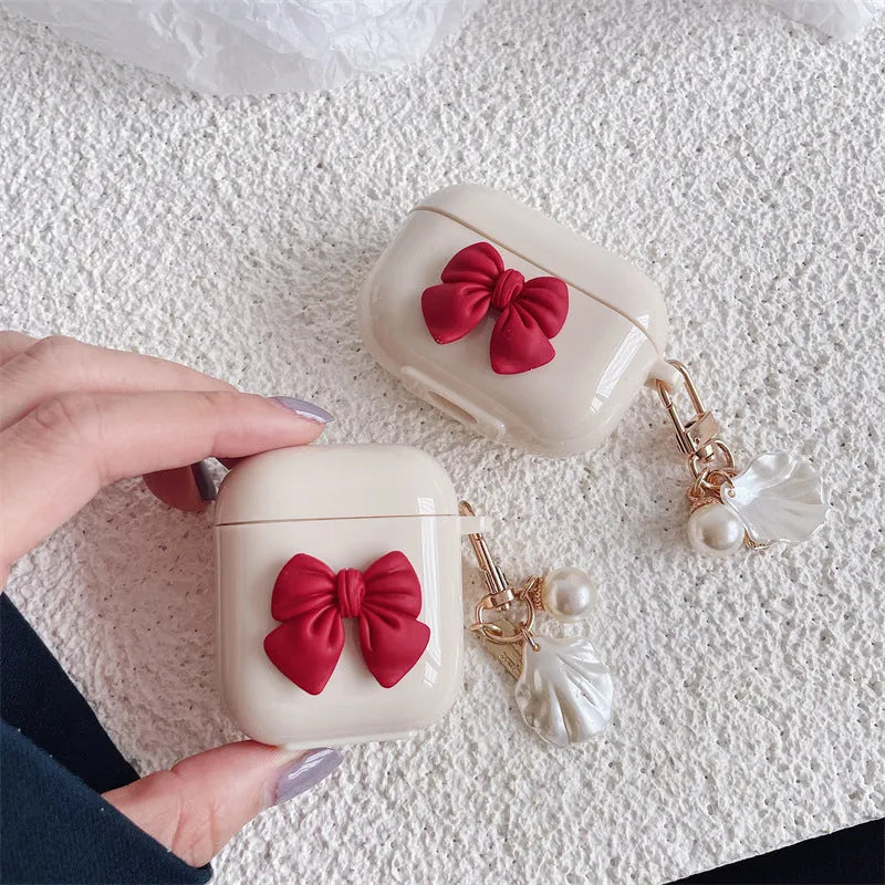 Beige AirPods case with red bow shell design, clamshell TPU earphone cover
