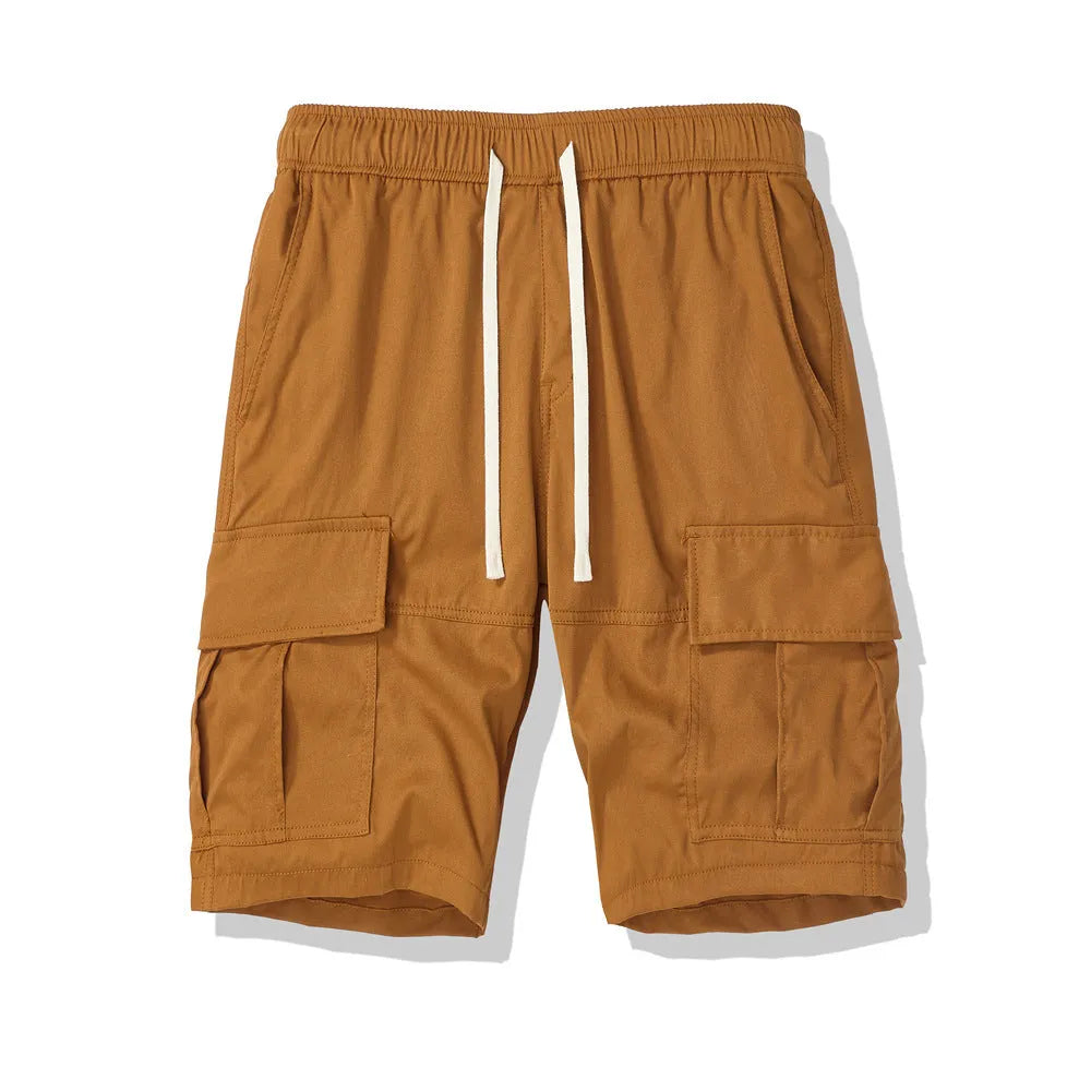 Man wearing loose fit, cropped multi-pocket trousers in a dark colour for casual summer wear.