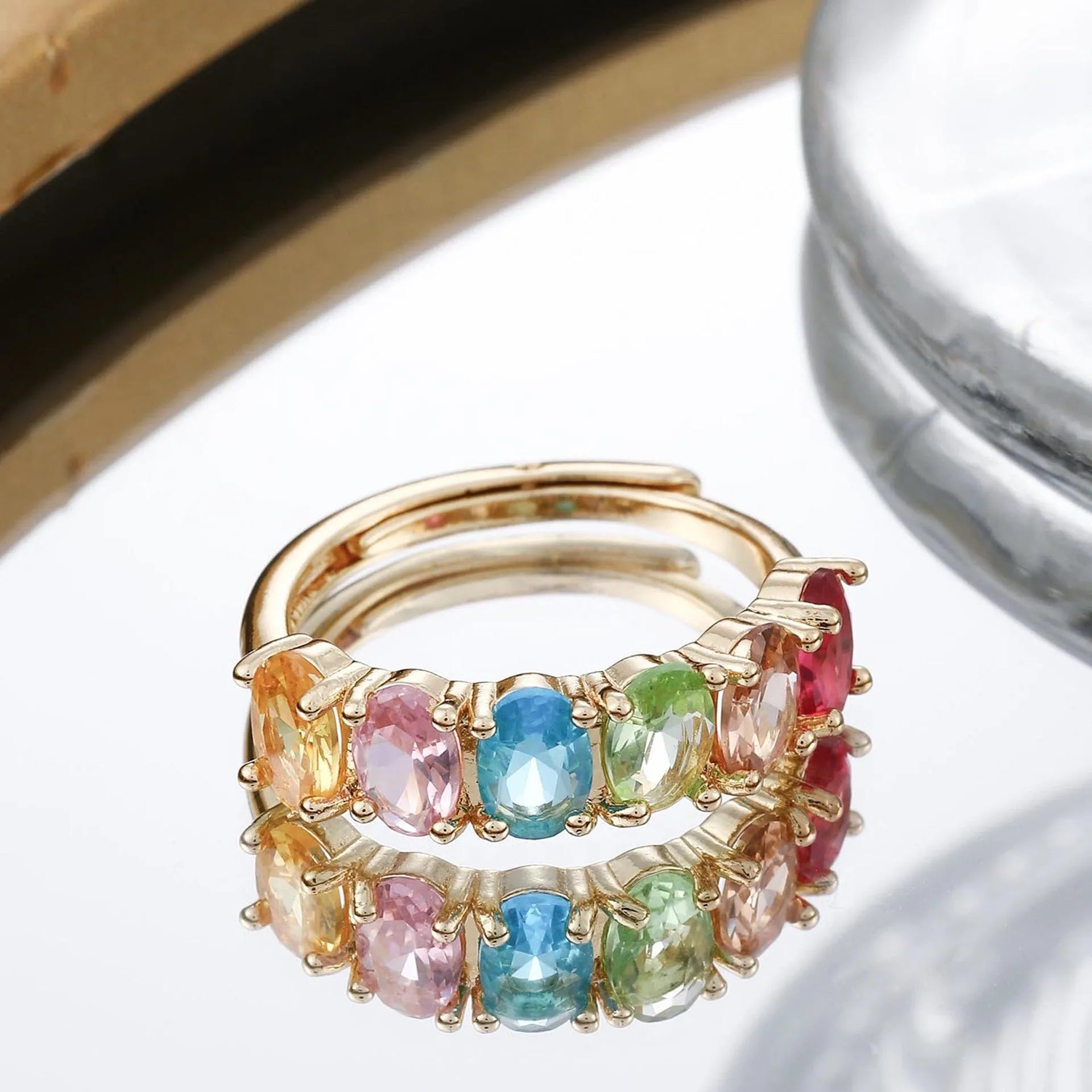 Adjustable gold women's ring with zircon accent on white background