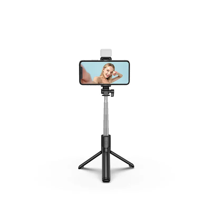 Black Bluetooth selfie stick with extended tripod legs and a phone mounted in its 360-degree rotating holder.