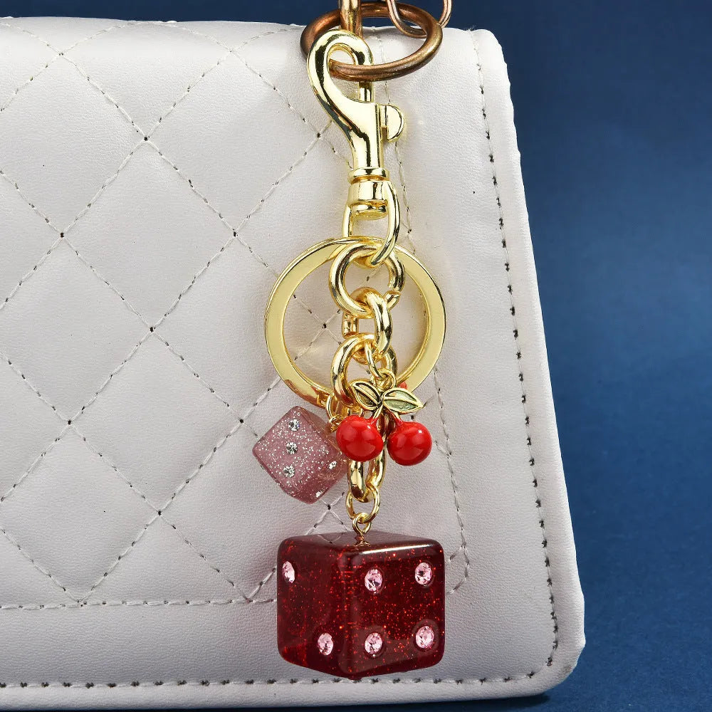 Vintage cherry two-tone square metal dice bag keychain pendant on a keyring.