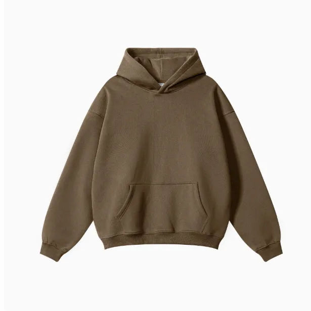 Man wearing a loose grey hooded terry cotton sweater with drop-shoulder sleeves.