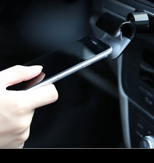 Black universal gravity car phone holder showing 360-degree rotation, mounted on a car air vent.