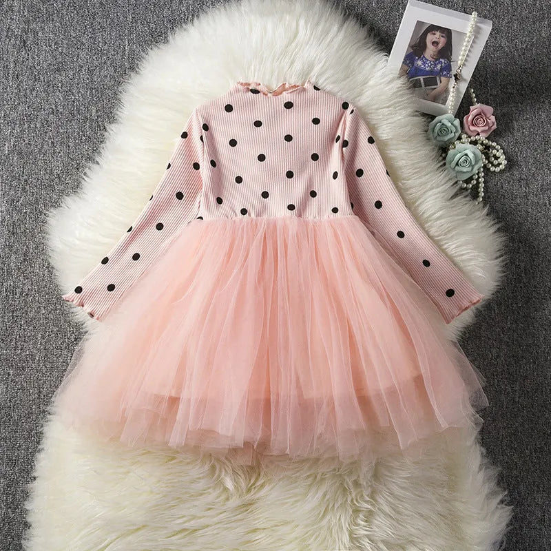 Baby girl in a long sleeve black tutu lace dress for a birthday party or christening