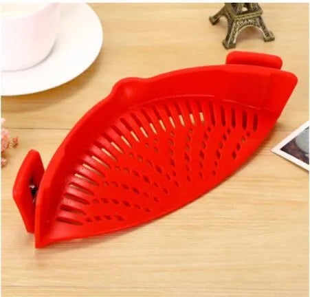 Silicone clip-on funnel strainer attached to a pot rim, showing hollow design and stainless steel buckle.