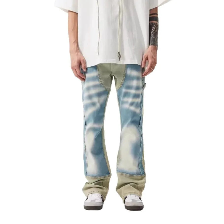 Yellow and blue retro patchwork jeans with splash-ink distressed detailing, showing mid waist and zip fly.