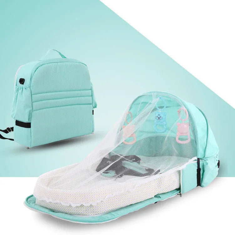 Portable foldable baby anti-mosquito isolation bed with grey cotton linen fabric, open on a grassy area