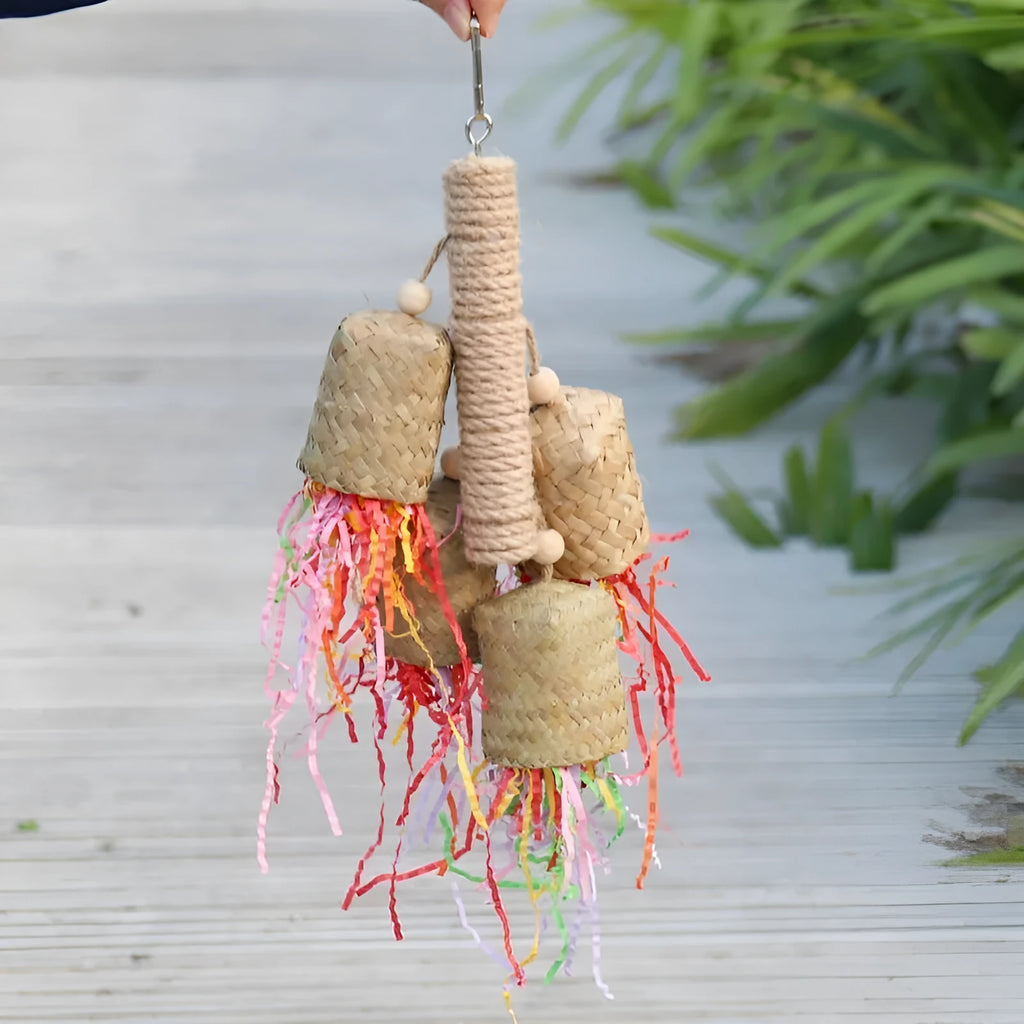 Wooden parrot toy with colourful shredded paper hanging by sisal rope
