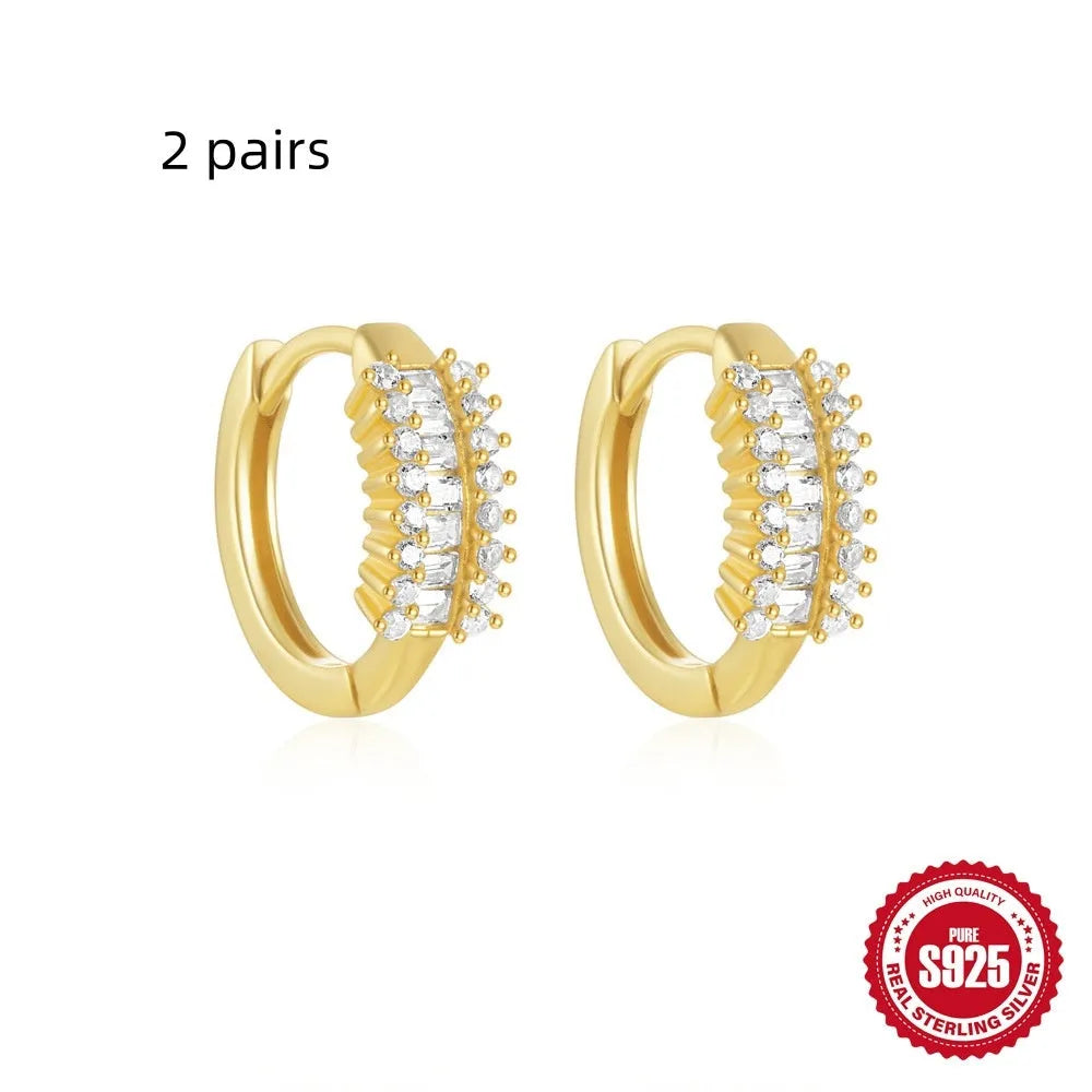 A pair of small, round, geometric stud earrings made of sterling silver with an electroplated finish.
