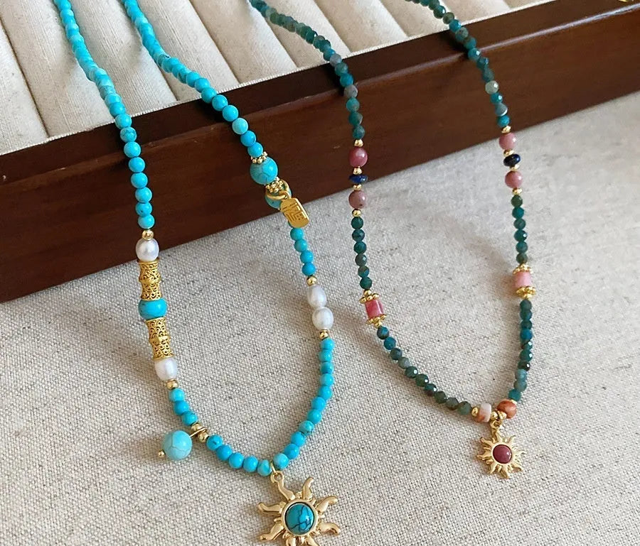 French royal court style necklace with freshwater pearls and a stone sun pendant on an adjustable chain.