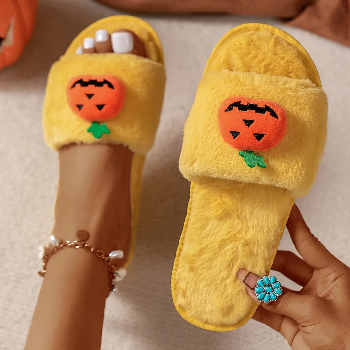 White and yellow Halloween cartoon pumpkin plush open-toe slippers with anti-slip PVC soles.