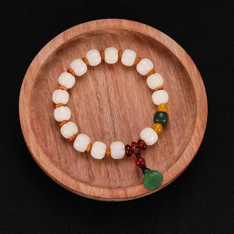 Carved pumpkin and lotus bead bracelet made from Bodhi root with white jade and aventurine details.
