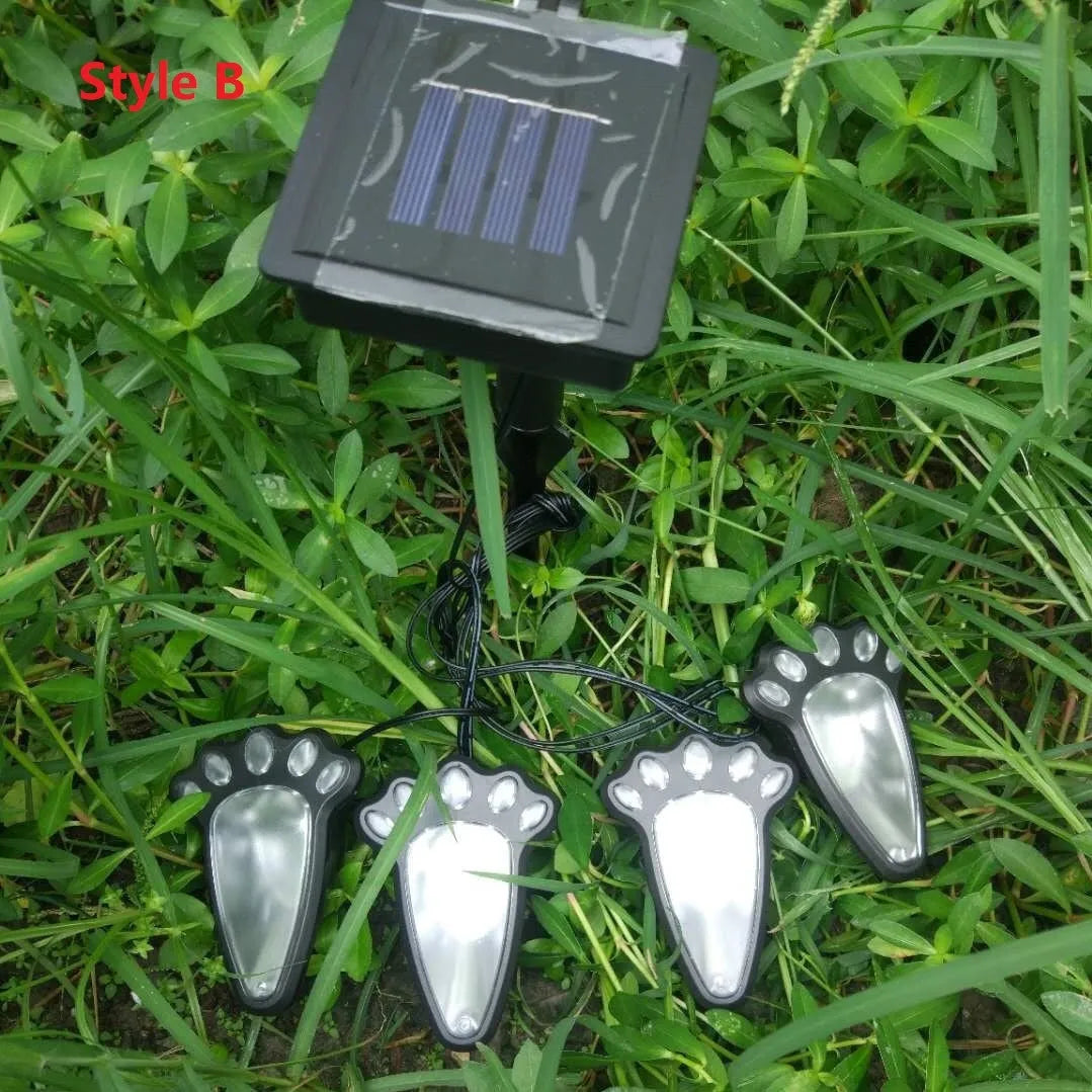 Black solar powered animal paw print LED garden lights set with four paw shapes and solar panel