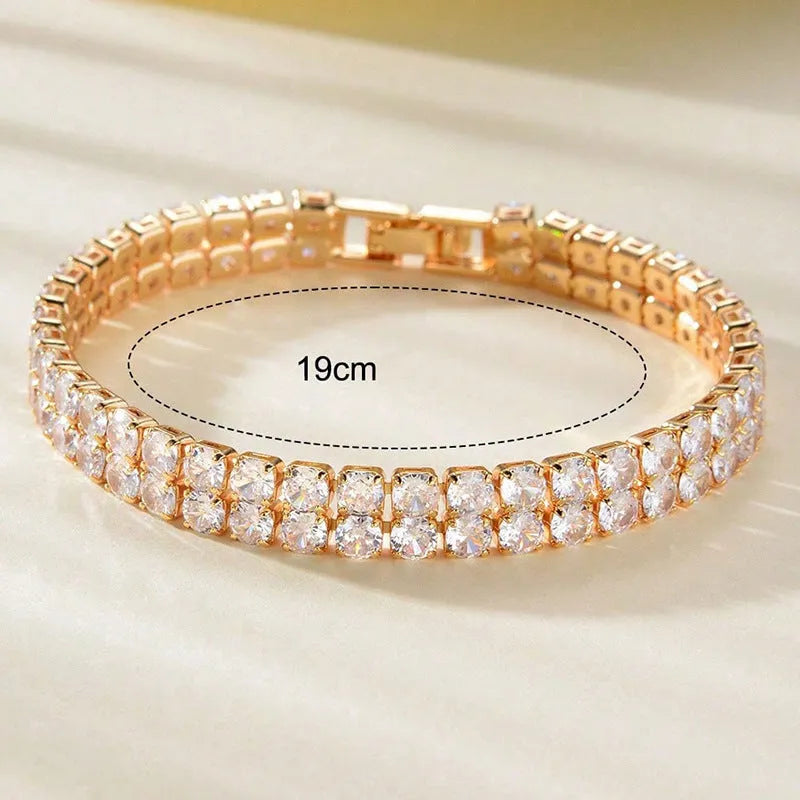 Unisex gold electroplated double-row diamond zirconia tennis chain bracelet on white background