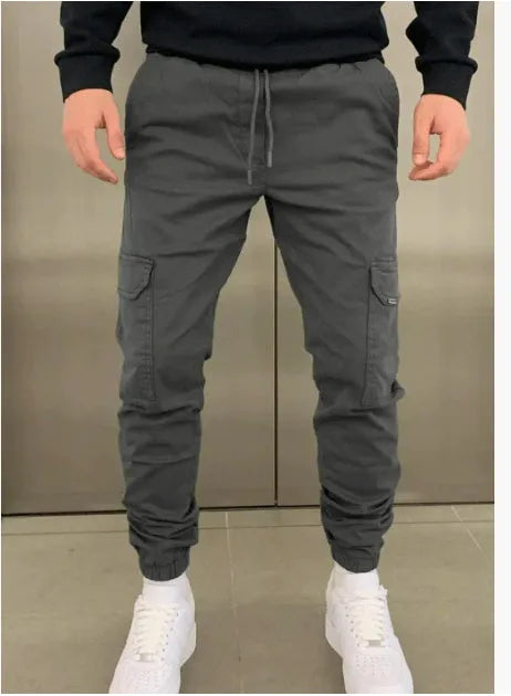 Men's light blue polyester baggy pants with patch pockets and elastic waistband laid flat