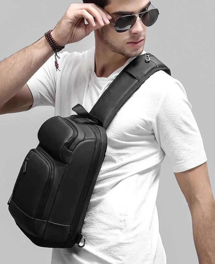 Black PVC medium shoulder bag with multiple internal compartments and adjustable strap