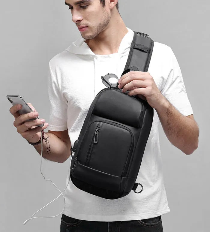 Black PVC medium shoulder bag with multiple internal compartments and adjustable strap