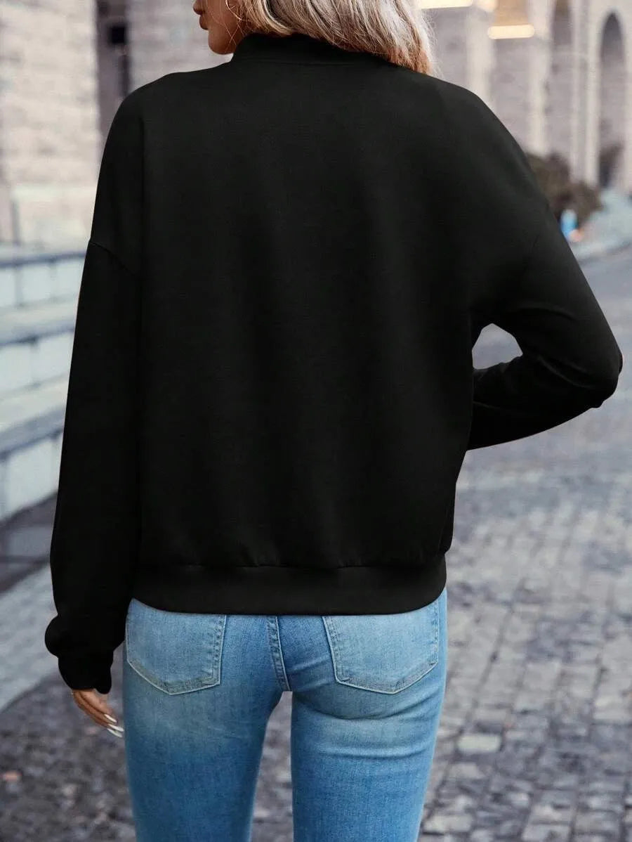 Women's solid black long sleeve zip jacket on a hanger, front view.