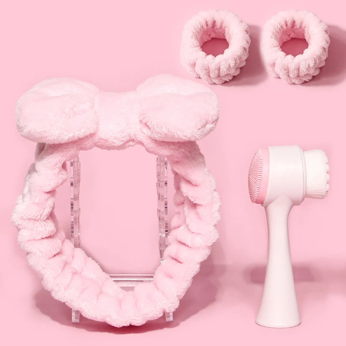 Facial brush with plastic handle and nylon bristles alongside coral fleece absorbent hair band in purple colour