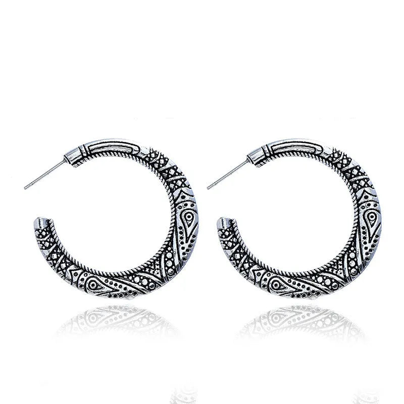 Vintage engraved bronze C-shaped alloy earrings showing curved silhouette and surface detailing