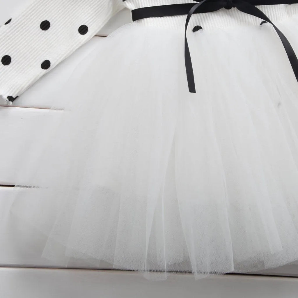 Baby girl in a long sleeve black tutu lace dress for a birthday party or christening