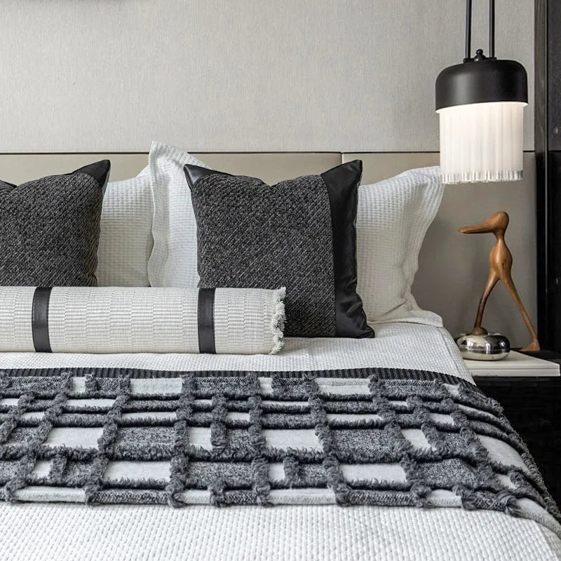 Modern minimalist plaid bed runner set with blanket, pillowcase, and round leather pillow on a bed