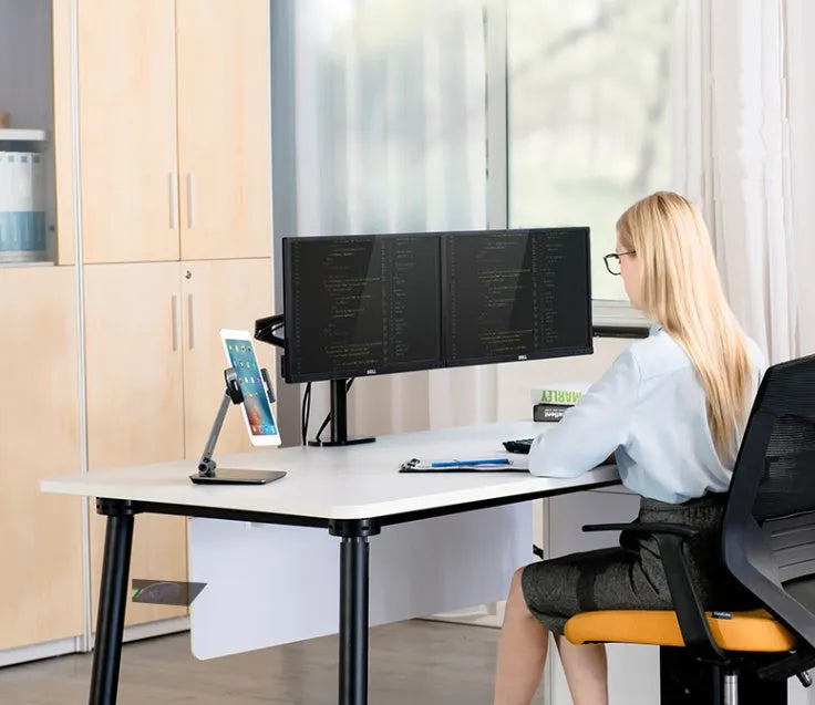 Folding aluminium desktop phone and tablet stand with 360-degree rotation on a wooden desk.