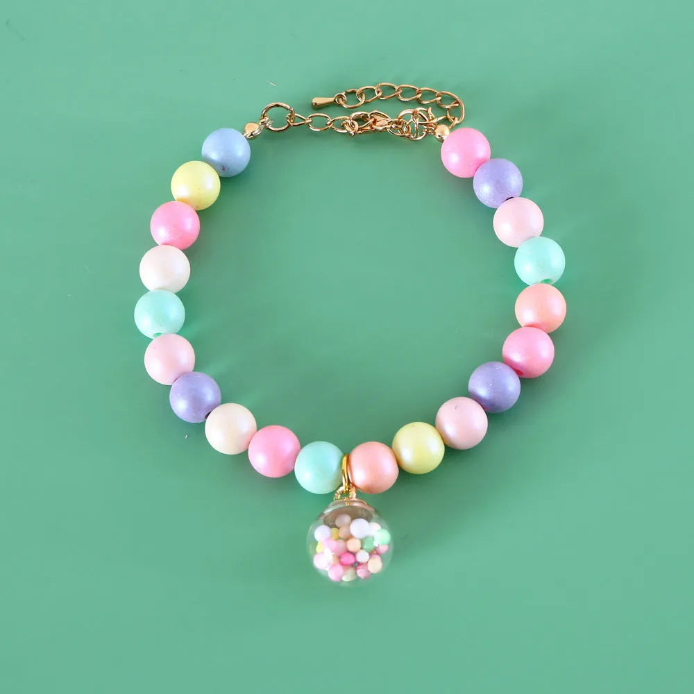 Colourful macaron charm pet collar and matching bracelet set in resin on a white background.