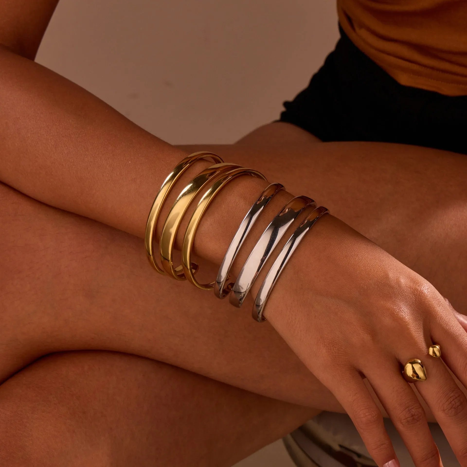Geometric stainless steel women's bracelet with simple opening, available in gold or steel colour with linear design elements