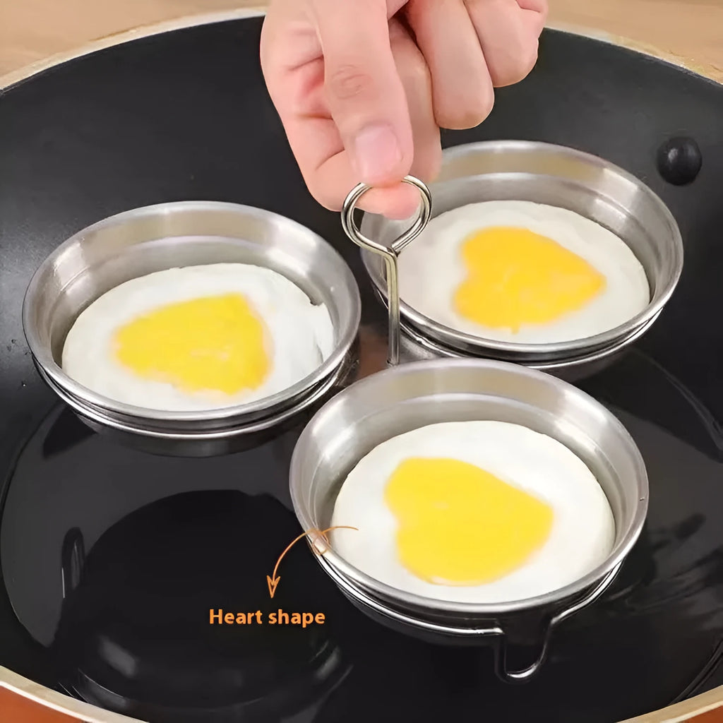 Small stainless steel heart-shaped egg steamer or cooker on a kitchen counter.
