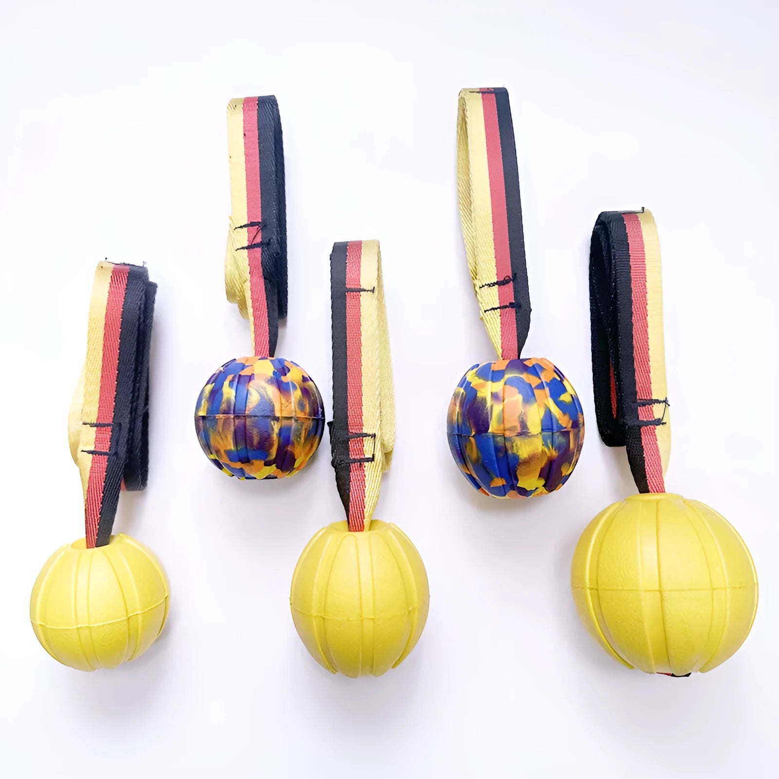 Camouflage and yellow EVA foam floating dog training balls in three different sizes on a blue background.