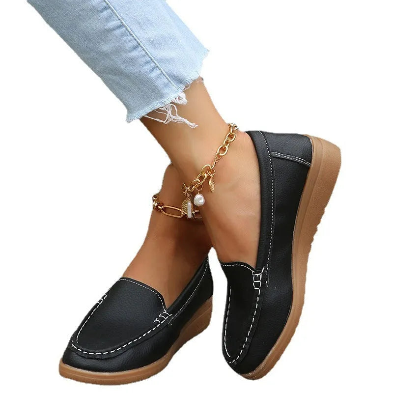 Women's black PU leather flat shoes with round toe and visible car suture stitching detail.
