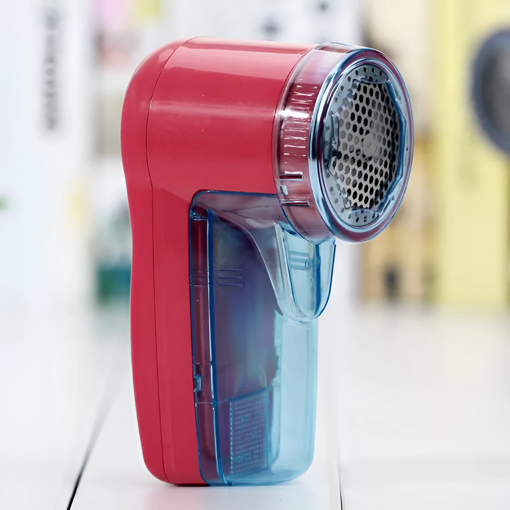 White handheld electric lint remover for clothing on a grey background showing its compact size.