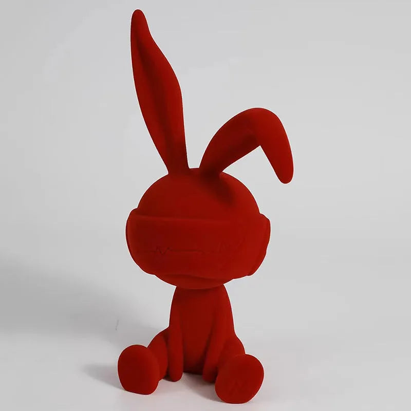Suede blindfold rabbit resin table ornament in chosen colour on a wooden surface.