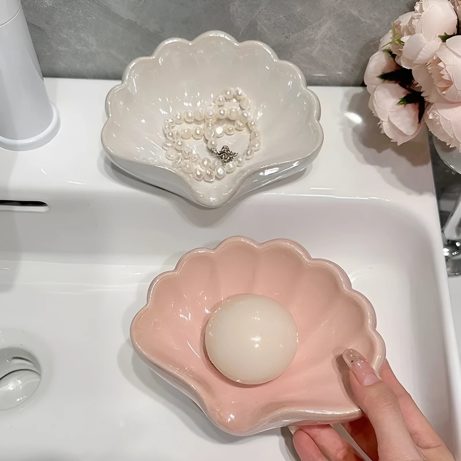 Plastic shell-shaped soap dish in pearl white or pink colour for bathroom organisation