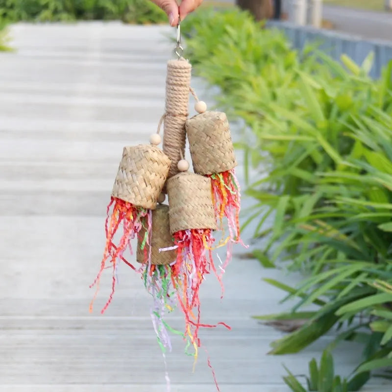 Wooden parrot toy with colourful shredded paper hanging by sisal rope