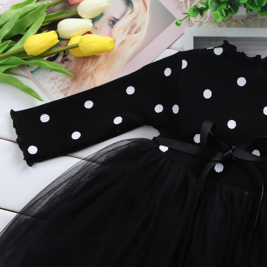 Baby girl in a long sleeve black tutu lace dress for a birthday party or christening