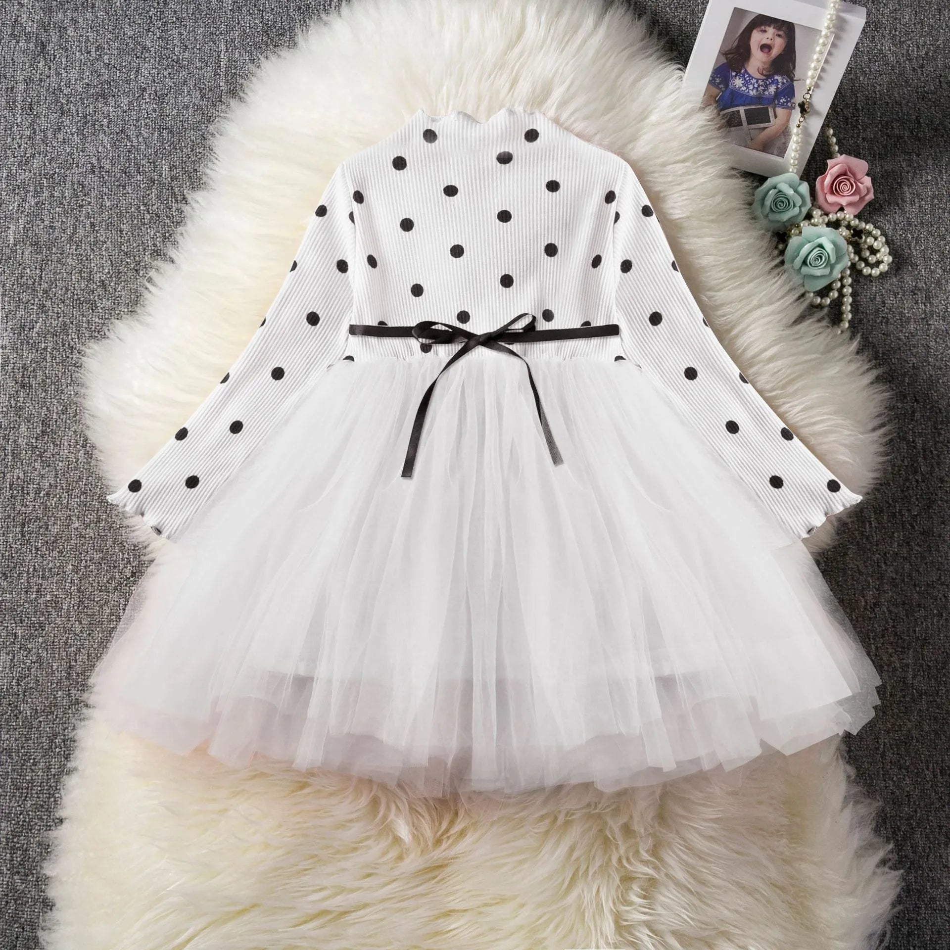 Baby girl in a long sleeve black tutu lace dress for a birthday party or christening