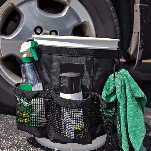 Black cylindrical polyester storage bag hanging on a 5 gallon barrel for tools and toiletries.