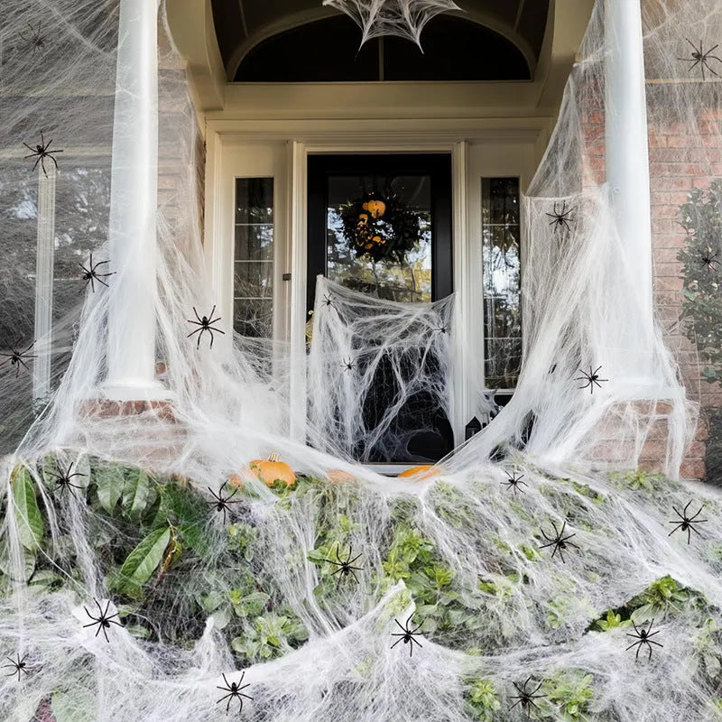 White cotton Halloween spider web decoration draped with plastic spider props.