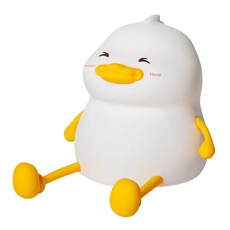 Chubby white silicone rechargeable night light on a wooden desk surface.