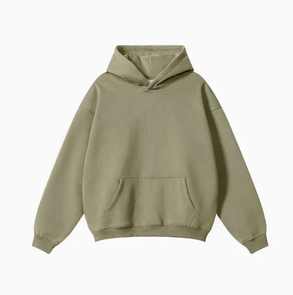 Man wearing a loose grey hooded terry cotton sweater with drop-shoulder sleeves.