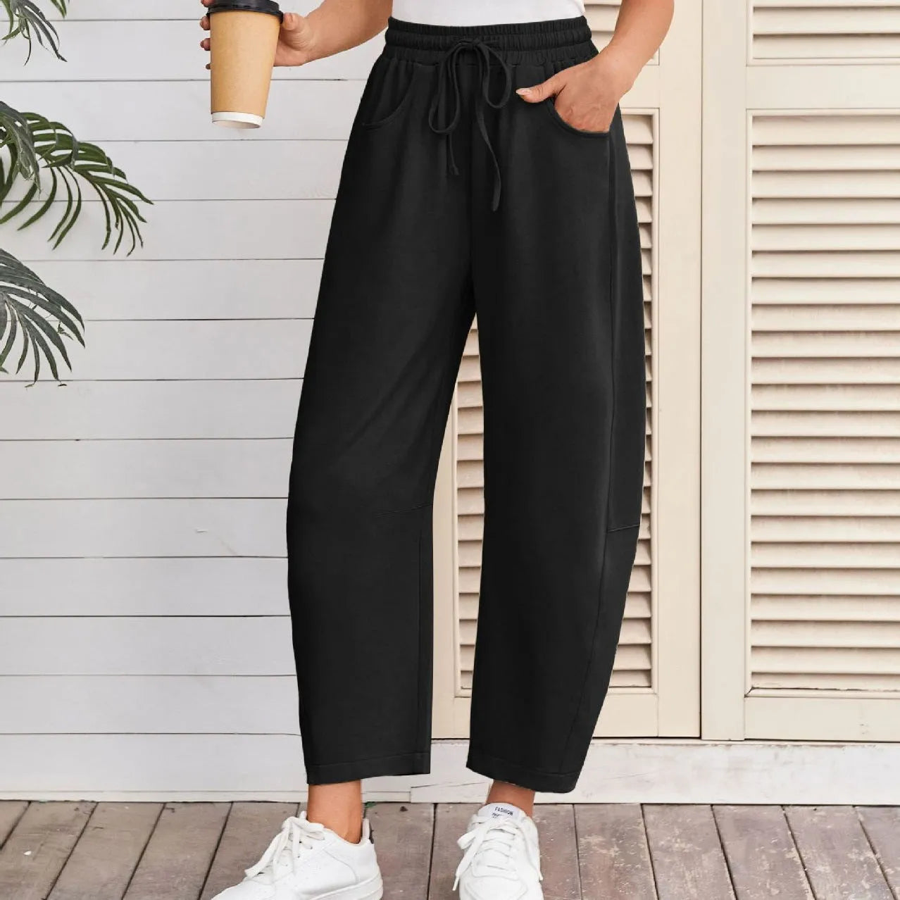 Loose grey cropped sweatpants with elastic drawstring waist and pockets on a mannequin