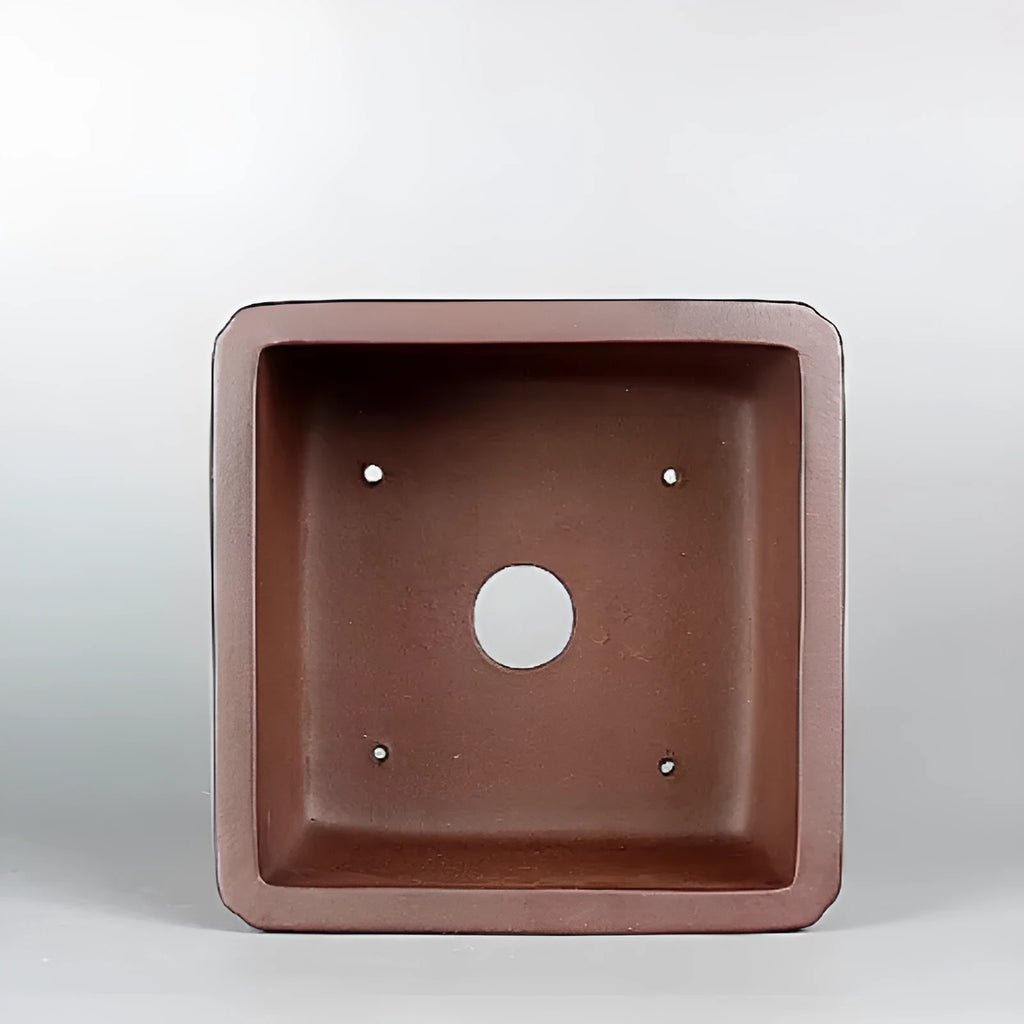 Brown handmade purple clay antique flower pot with drainage hole.