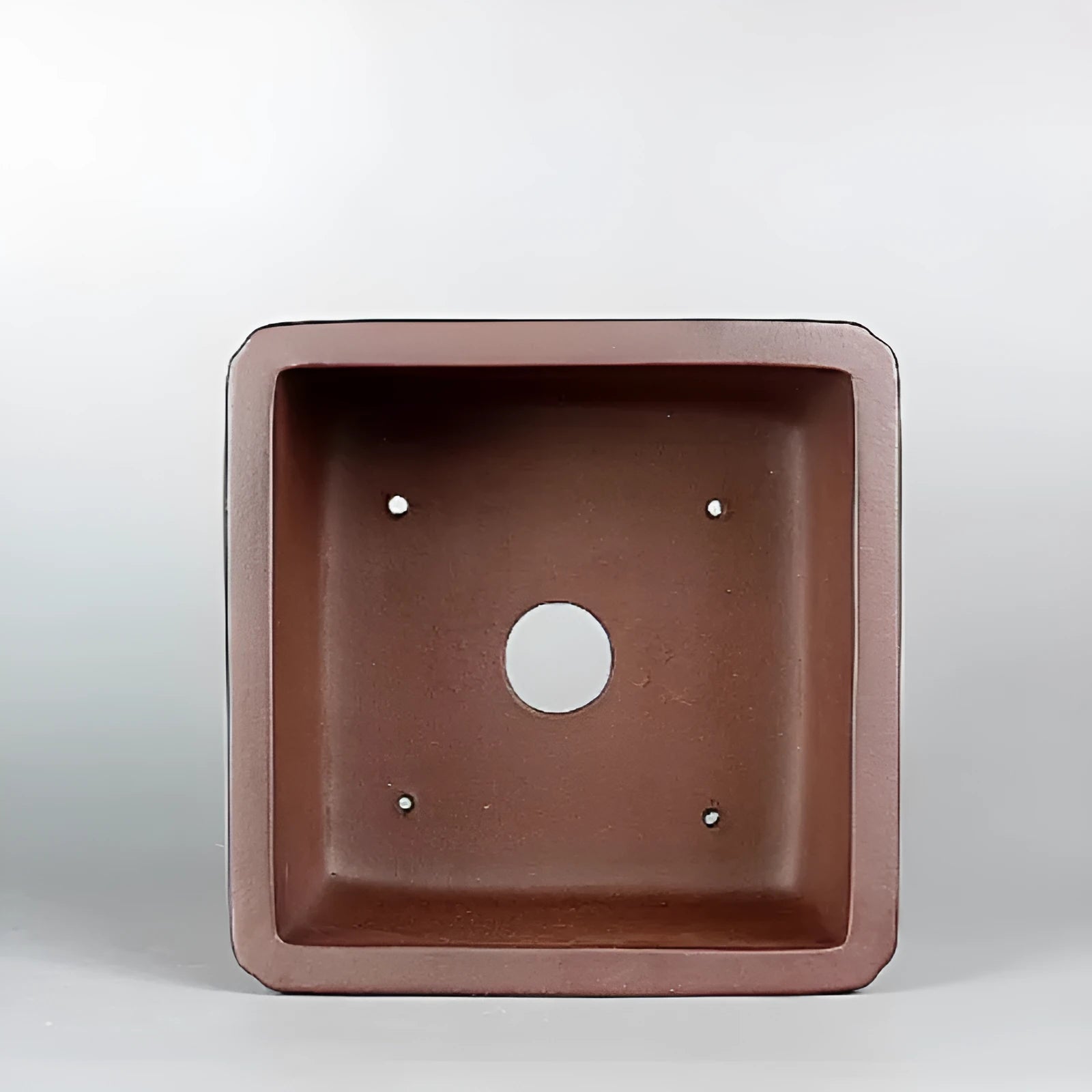 Brown handmade purple clay antique flower pot with drainage hole.