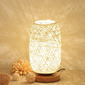 Brown hemp rope Sepak Takraw ball desk lamp with solid wood base on a desk.