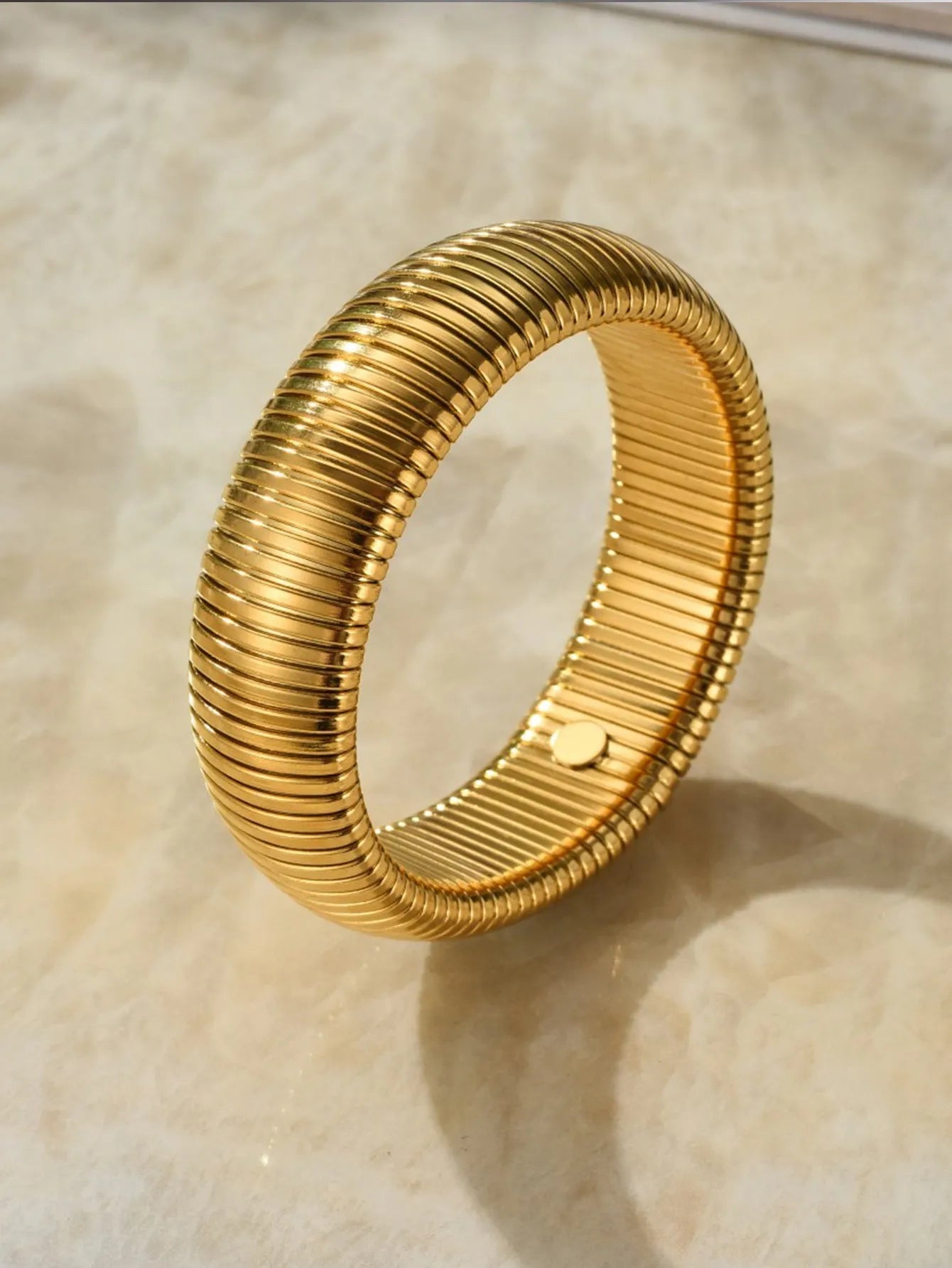 Gold titanium steel bracelet with elastic vertical stripe ring design, shown at 2cm width.