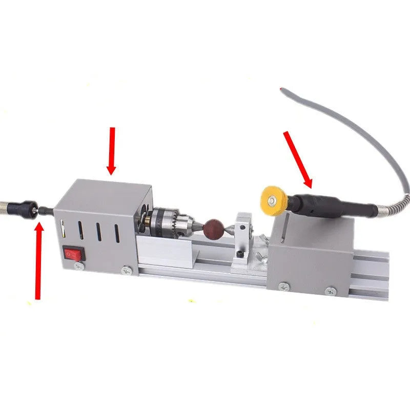 Mini silver metal manual woodworking lathe with carving knives on a workbench.