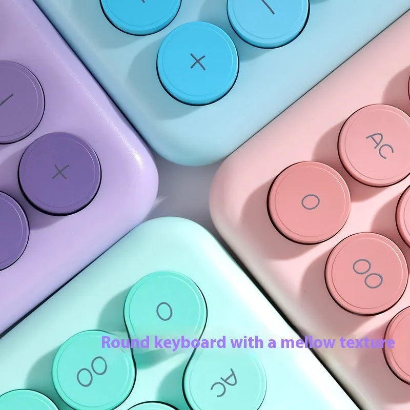 Desktop calculator with a gradient colour design in violet, blue, green, and pink tones on a white desk.