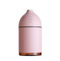 White ultrasonic aromatherapy diffuser with LED light and USB cable on a wooden table